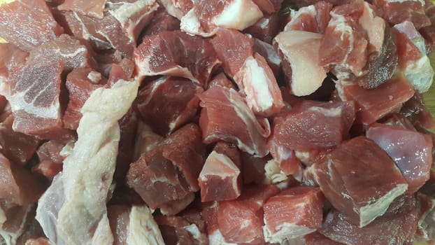Close up view of fresh finely chopped meat cubes. Red meat small steaks with whitish meat fat.