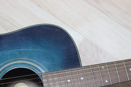 Close up of music guitar. Acoustic guitar with strings on a wooden floor