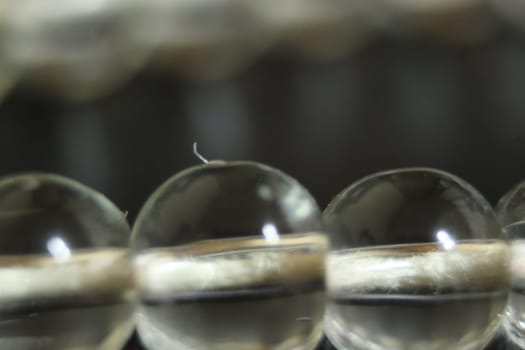 Macro photograph with selective focus of glass shiny prayer beads or rosary with copy space for text. Religion concept of ramadan or Eid for muslims.