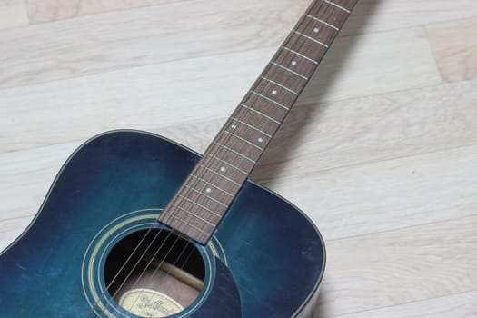 Close up of music guitar. Acoustic guitar with strings on a wooden floor