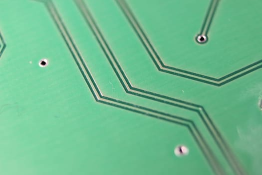Electronic board with circuit lines and chip. Macro view of green board