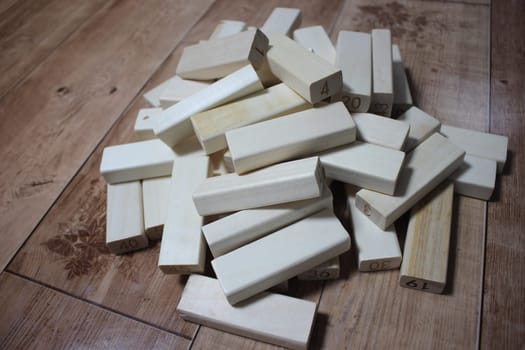 Pile of wooden blocks with engraved letters dispersed on floor. Children toy for building creative works.