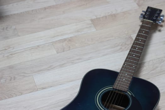 Close up of music guitar. Acoustic guitar with strings on a wooden floor