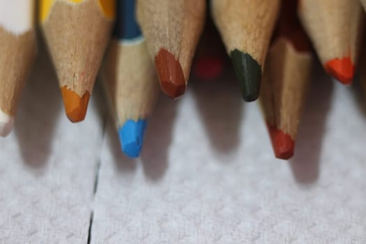 Close-up view of bright colored multicolor pencils on black background