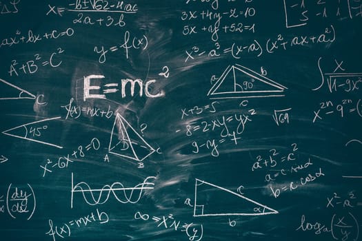 Blackboard inscribed with scientific formulas and calculations in mathematics. Science and education background.