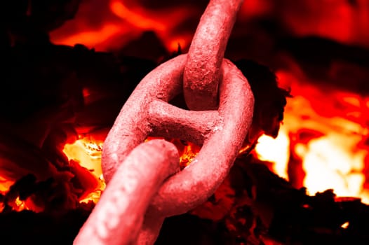 Iron chain links heated by a furnace fire. Blacksmithing craft. Limit state. Hot metal. Whipping up relationships. Background image. Magazine cover. Template with place for text. Poster. Metallurgy.