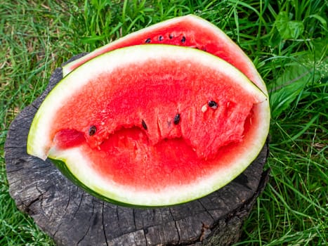 Red watermelon with seeds cut with a knife. Berry. Food photo. Place for your text. Harvest of watermelons. Background image. Poster. Advertising photo of a shop window. Summer season. Fruits.