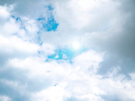 The sun on the background of the cloudy sky. Background image. Sun glare. Camera lens flare. Place for text. Poster. Template. Cloudy landscape. Weather cyclone. Windy weather. Climate change.