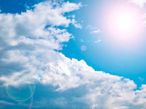 The sun on the background of the cloudy sky. Background image. Sun glare. Camera lens flare. Place for text. Poster. Template. Cloudy landscape. Weather cyclone. Windy weather. Climate change.