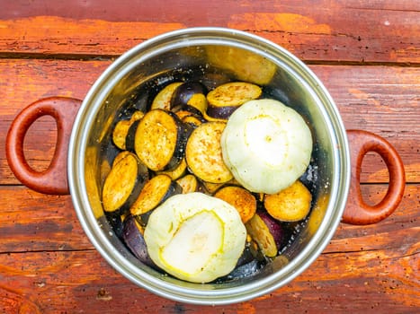 Blue eggplant vegetables and squash in a kitchen saucepan. Food photo. Harvesting vegetables. Advertising photo of a shop window of a vegetable store. Cooking food. Place for text. Poster. Menu.
