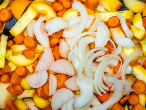 Sliced and peeled vegetables with onions and carrots for cooking. Food photo. Vegetable harvest. Home kitchen. Cooking food. Place for your text. Advertising photo of a shop window. Template.