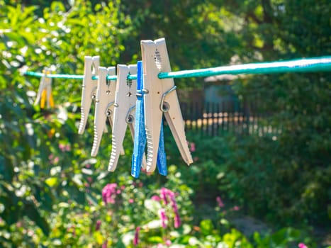 Clothespins hang on a clothesline to dry the clothes. Household. Gen. Background image. On the street. Place for text. Template. Poster.