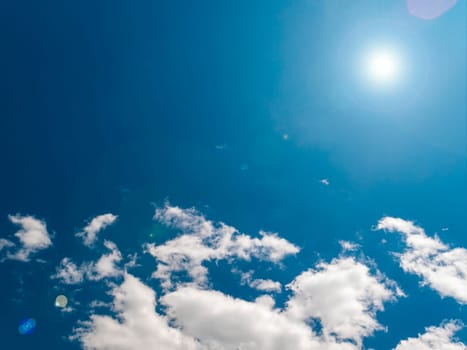 Sun on a background of blue sky with clouds. Sun rays with glare. Space. Stratosphere. The ozone layer of the earth. Cloudy landscape. Background image. Template for text. Poster.