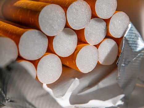 A closeup of cigarette filters in a pack. The tobacco industry. The harm of nicotine. Filtered cigarettes. The cigarette industry. Background image. Place for your text. Health and medicine.