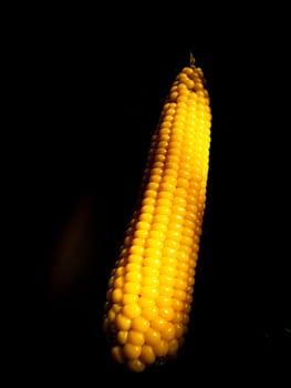Yellow swing of corn on a black background. Boiled corn. Harvest. Agriculture. Food photo. Black background. Place for your text. Background image. Poster. Vegetarian food.
