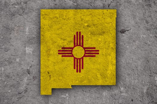 Map and flag of New Mexico on weathered concrete