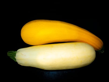 Yellow vegetable zucchini on a black background. Food photo. Vegetarianism. Vitamins in vegetables. Cooking zucchini boluda. Harvesting. Agriculture. Menu of dishes. Background image.