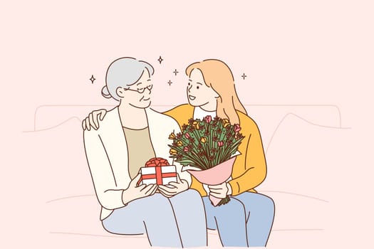 Mothers day holiday, women in family concept. Beautiful young woman and her mother with flowers and present box sitting and hugging at home, feeling care and love vector illustration