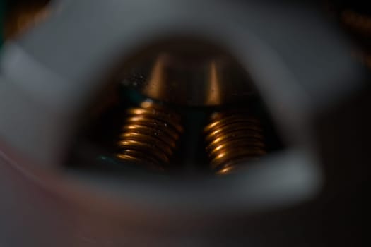Dark close up of shiny copper coils within a brushless drone motor. Copy space and selective focus with cinematic color style. Super macro scale.