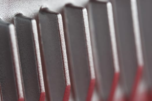 Aluminium or Aluminum heat sink cooling fins. Full frame super macro close up, showing metal detail and coarse finish. Red and silver color theme.