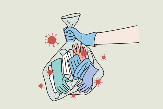 Pandemic, epidemic, coronavirus infection concept. Human hands wearing blue protective gloves carrying rubbish bags containing infected gloves and infected surgical mask during pandemic