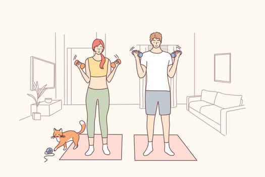 Healthy active lifestyle, training at home concept. Active young happy couple doing workout with dumbbells on fitness mats at home during quarantine pause and enjoying time together