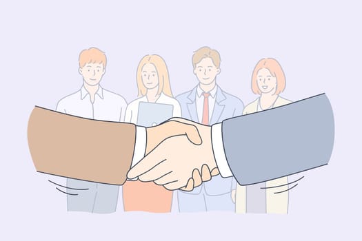 Handshake, partnership, business cooperation concept. Group of smiling young business workers colleagues standing and looking at shaking hands of head managers meaning collaboration in office