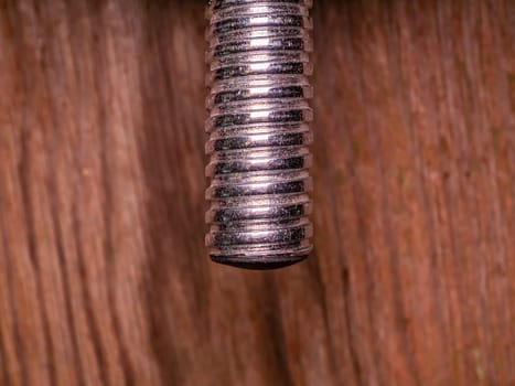 Iron bolt with thread for tightening the nut. Threaded connection of parts with a bolt and a nut. Parts fastening technology. Locksmith accessories. Background image. Place for your text.