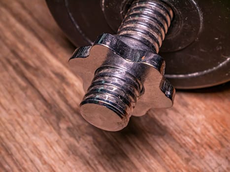 Iron bolt with thread and twisted nut. Threaded connection of parts with a bolt and a nut. Parts fastening technology. Locksmith accessories. Background image. Place for your text.