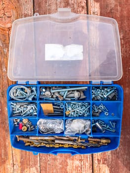 Working tool plastic case with bolts and nuts. Threaded connection of metal parts. Parts fastening technology. Drill bits. Locksmith accessories. Background image. Place for your text.