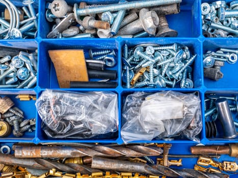 Working tool plastic case with bolts and nuts. Threaded connection of metal parts. Parts fastening technology. Drill bits. Locksmith accessories. Background image. Place for your text.