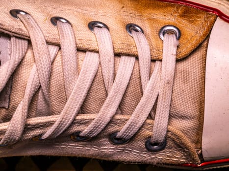 Lacing an old sneaker with white laces. Sports sneakers. Lace up your shoes. Shoe laces. Background image. Place for your text.