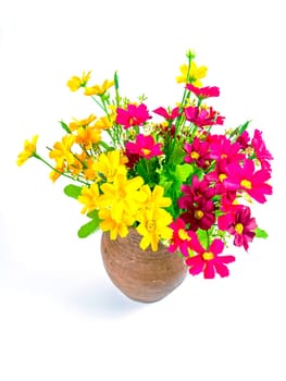 A bouquet of artificial flowers in a clay jug. Bouquet of pink and yellow flowers. Ceramic vase. Earthenware. Handmade. White background. Background image. Place for your text.