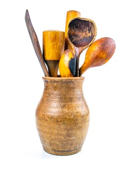 Ceramic clay jug with wooden kitchen utensils. Old kitchen utensils. Handmade clay jug. Wooden kitchen spoons. White background. Background image. Place for text.
