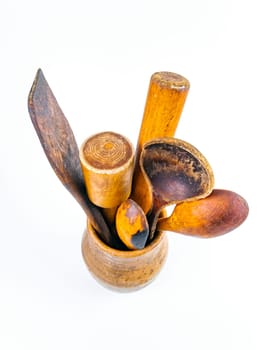 Ceramic clay jug with wooden kitchen utensils. Old kitchen utensils. Handmade clay jug. Wooden kitchen spoons. White background. Background image. Place for text.