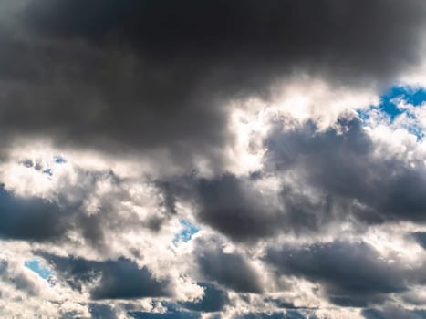 Cloudy sky with thunderclouds illuminated by sunlight. Thunderclouds. Blue sky. Atmospheric cyclone. Weather. Non flying weather. A hurricane or storm is approaching. Background image.