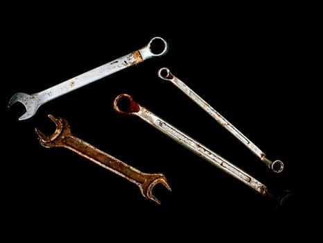 Hand tools metal wrenches on a black background. Hand-held locksmith tools. Wrench. Tighten screws and nuts. Locksmith work. Mechanic. Work. Place for text. Background image. Poster.