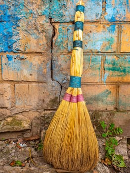 Wicker broom made of sorghum for indoor sweeping. Broom for sweeping the floor. House cleaning. Cleaning of office premises. Cleanliness and tidiness. Cleaning of the territory. Tool.