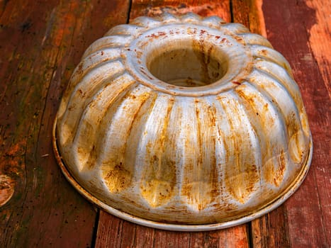 Aluminum bakeware for baking in the oven. Aluminum baking dish made of flour dough. Wooden kitchen table. Home kitchen. Bakers tool. Cook equipment. Cooking utensils. Cooking a flour dish.
