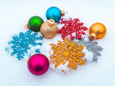 Christmas tree toys colored balls and snowflakes on white snow. Christmas holidays. New Year. Loose winter snow. New Years holidays. Winter vacation. Place for text. Greeting card.
