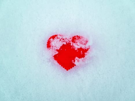 Valentine red heart symbol on white snow. Valentine's Day. Red valentine. Heart symbol. Day of Love. Feast in February. Valentine's day holiday. Fate. Engagement. Wedding. Greeting card.