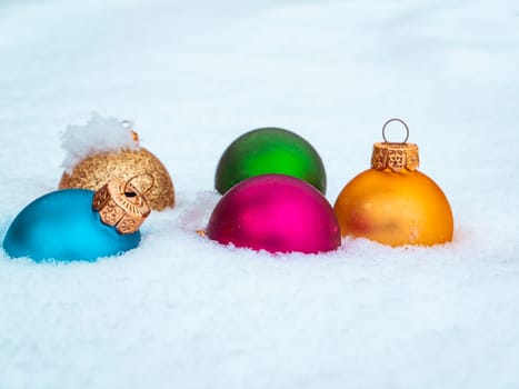 Christmas tree toys colored balls on white snow. Christmas holidays. New Year. Loose winter snow. New Year holidays. Winter vacation. White background. Place for text. Greeting card. Invitation.