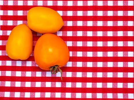 Yellow tomato vegetables on the kitchen table. Food photo. Harvesting tomato. Advertising photo of a shop window of a vegetable store. Agriculture. Farming activities. Place for text.
