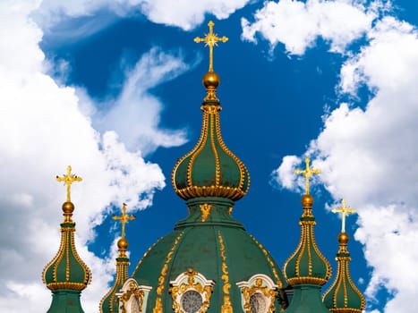 Domes with a cross of a Christian church. Christian cross. Religion and culture. Orthodox church. Blue sky. White clouds. Merry Christmas. Easter holidays. Background image.