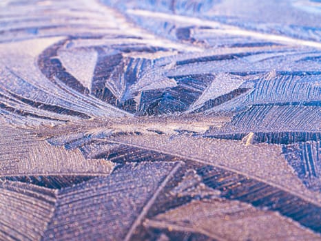 The texture of patterns of frost on the glass in winter. Frosty pattern on a glass window. White snow. Frozen water. Crystals of ice. Winter season. Weather. Weather forecast. Background image.