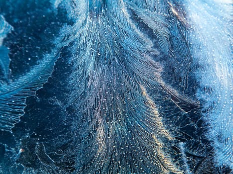 The texture of patterns of frost on the glass in winter. Frosty pattern on a glass window. White snow. Frozen water. Crystals of ice. Winter season. Weather. Weather forecast. Background image.