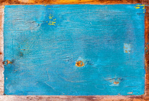 Faded texture of a wooden surface painted in blue. Peeling blue paint. Bough of a tree. Wood plywood texture. Aging process. Background image. Place for text. Cracks. Poster.