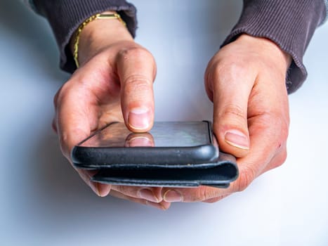 Black mobile phone smartphone in the hands of a man. Mobile phone. Smartphone gadget. Touch screen. Internet 5g. Human hands. Dialing a telephone number. Business and finance. Communication.