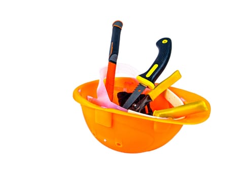 Work tool inside an orange safety helmet on a white background. Working tool. Plastic protective helmet for the worker. Worker tool. Hammer and pliers. Construction and repair. Background.
