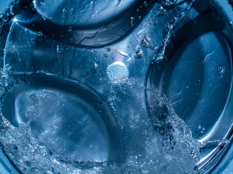 Rotating drum in the washing machine tub with water. Washer. Automatic laundry. Service and repair of equipment. Splashing water. Repair shop. Stainless steel tank. Centrafuga.